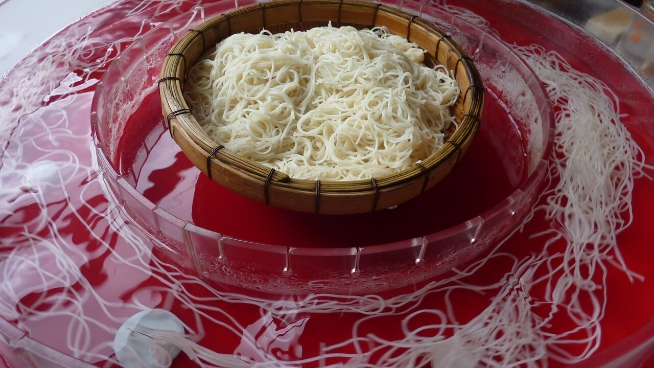 回転式の流しそうめん器を流れるそうめん