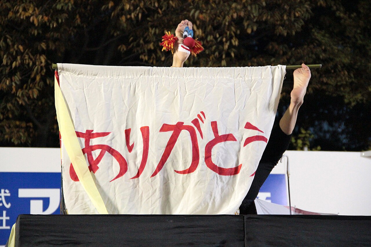 大道芸ワールドカップin静岡で「ありがとう」の幕を掲げるパフォーマー