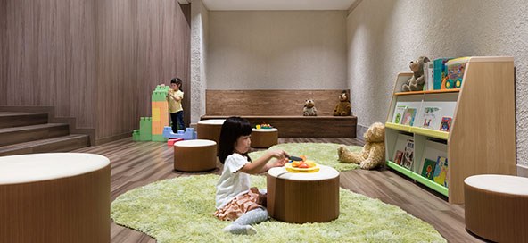 絵本とブロックが置かれたキッズルームで遊ぶ子ども