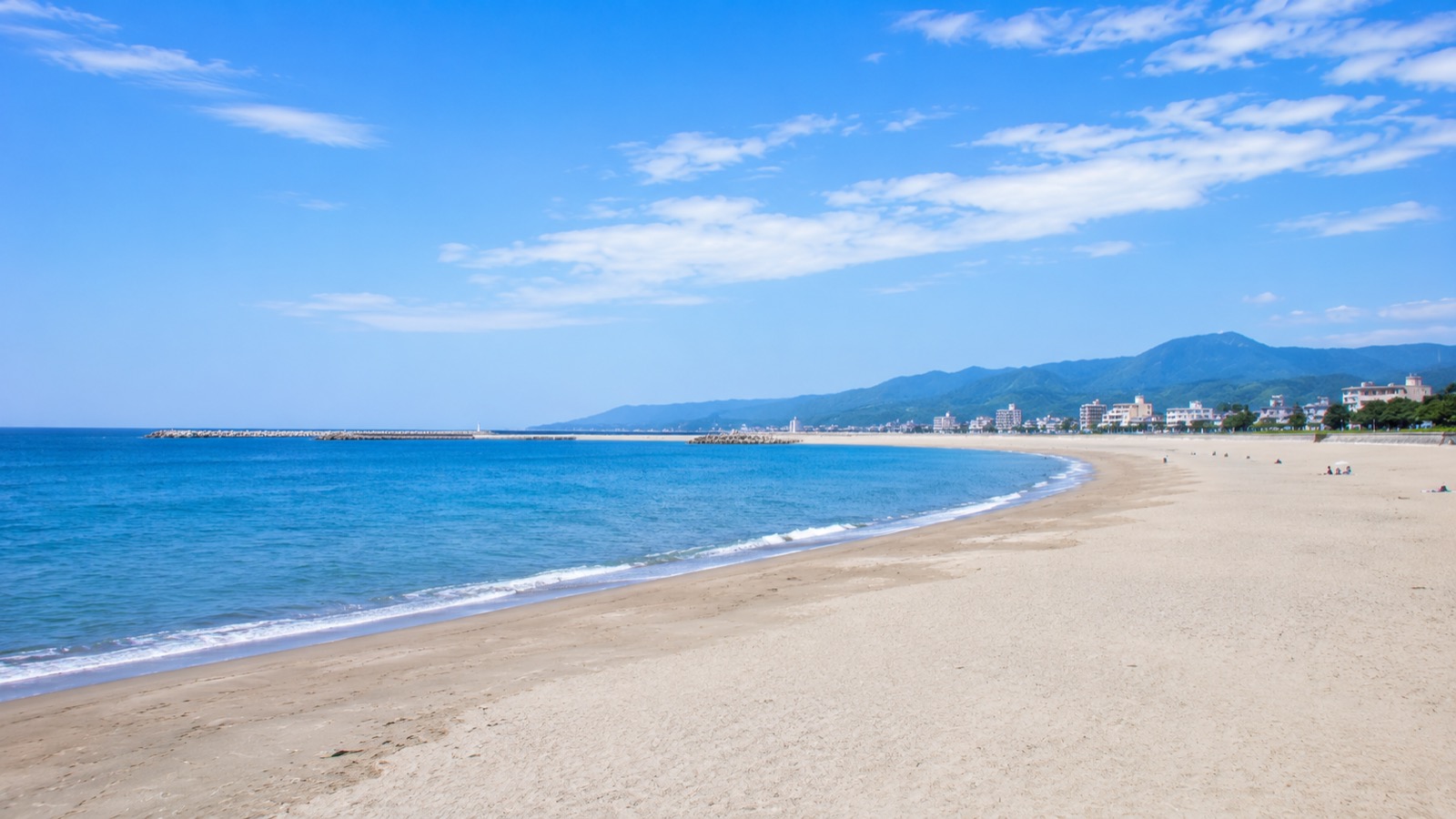 夏の終わりの晴れた日の長い砂浜と青い海