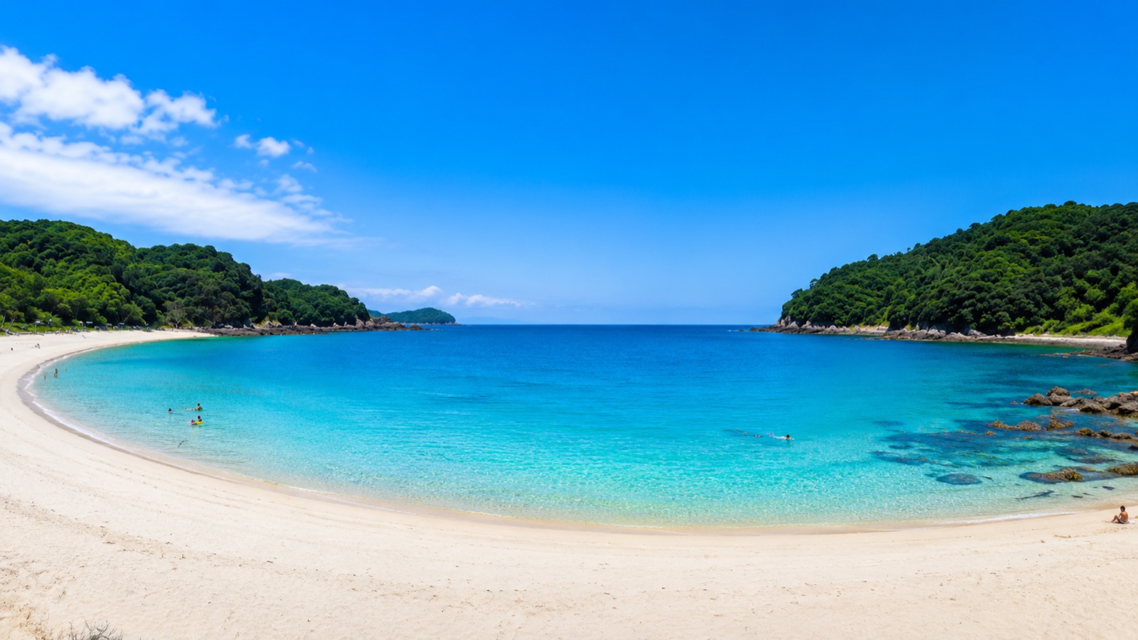 夏の晴れた日の弓ヶ浜海岸。透明度の高い青い海と弓なりの白い砂浜