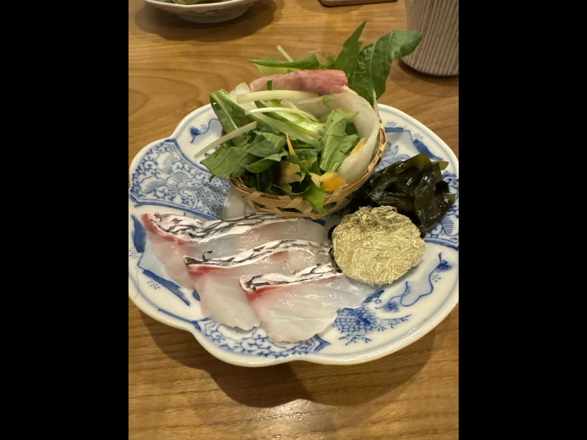 お通しの鍋の具材（魚の切り身・野菜・わかめ）