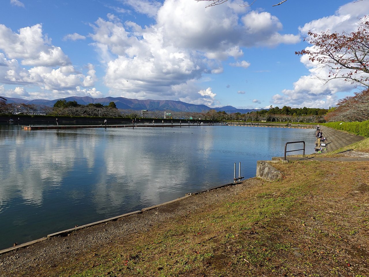 東山湖の岸辺に並ぶ釣り人と桟橋